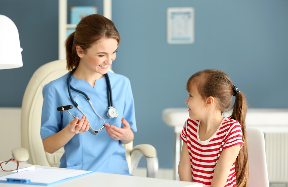 A pediatric nurse practitioner helps a young child feel at ease during an examination.