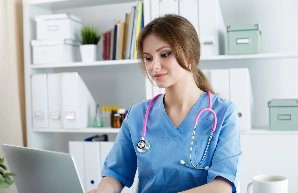 A registered nurse sits with her laptop studying for her bachelor’s degree.