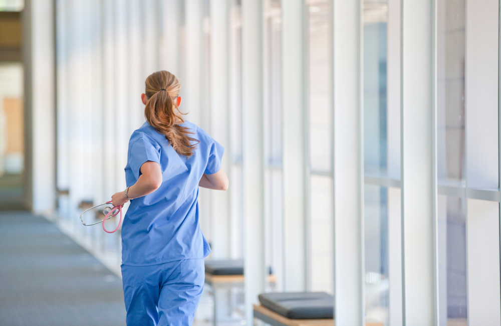 A nurse rushes down a hospital corridor to help assist in an emergency.