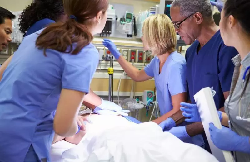 Several nurses work together to treat one patient.