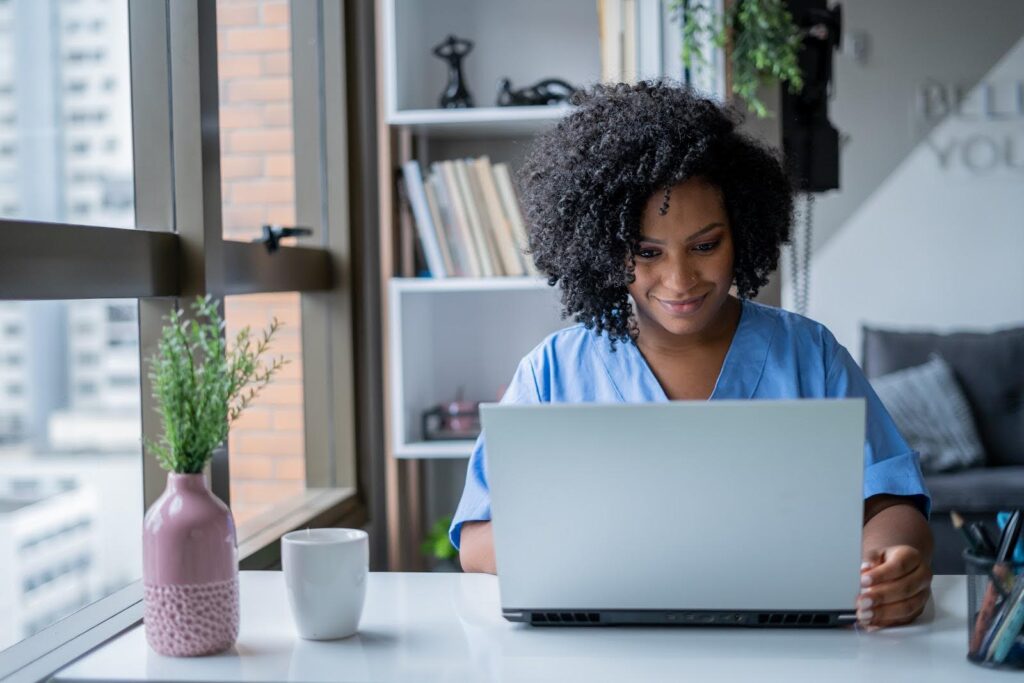 A Master of Science in Nursing student works at a laptop computer to complete an online assignment.